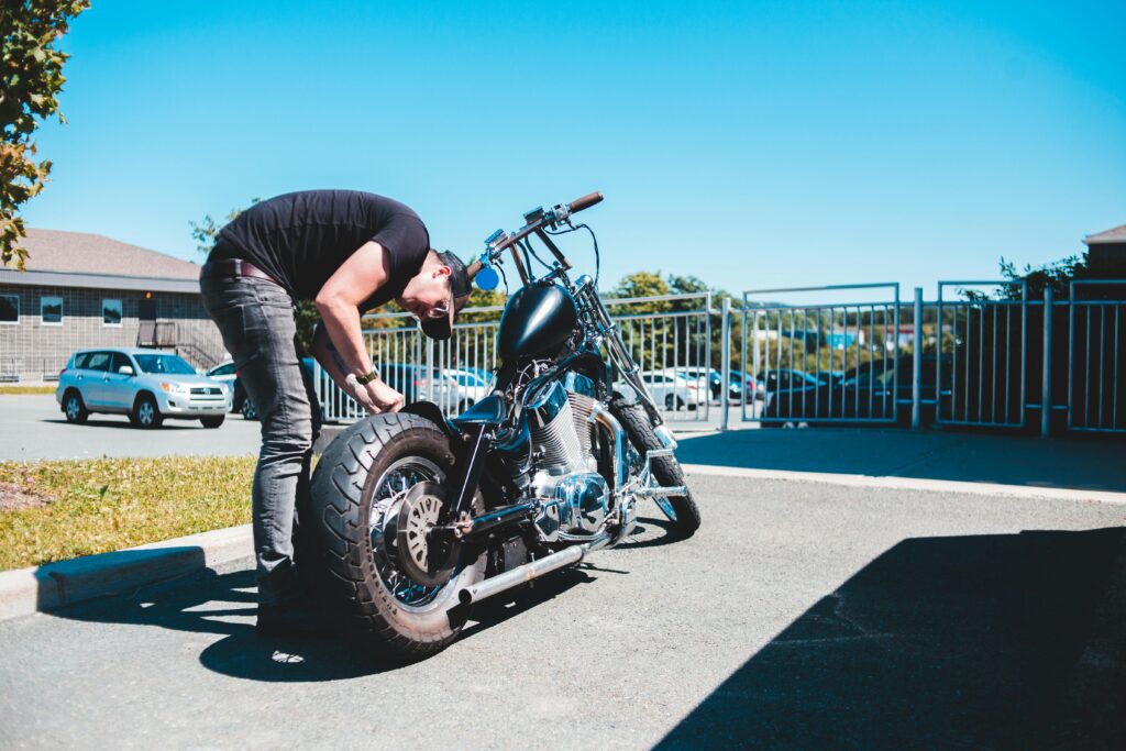 person checking tires for motorcycle maintenance